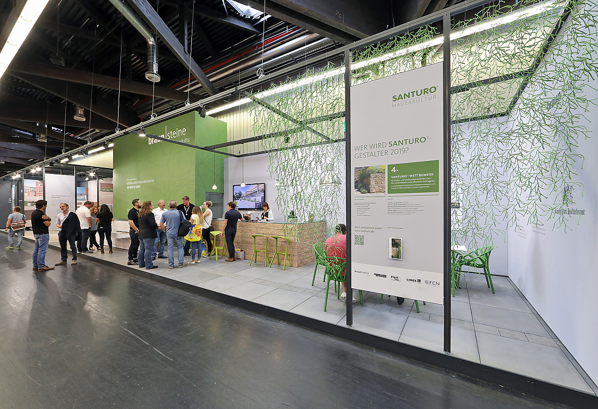 Besucher an einem Messestand von braun-steine