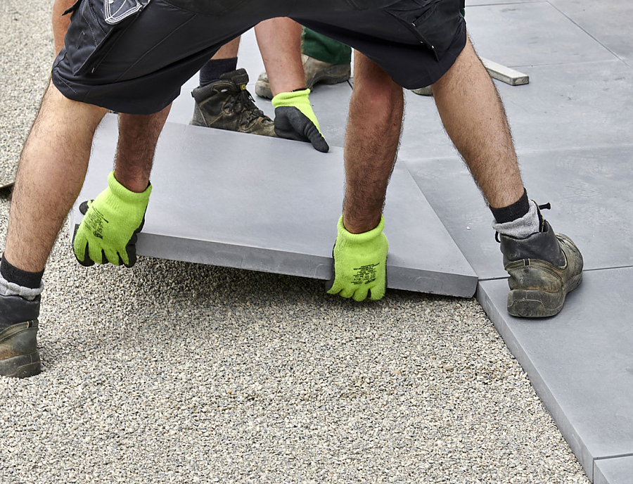 Ein Arbeiter verlegt CEMENTO Terrassenplatten.