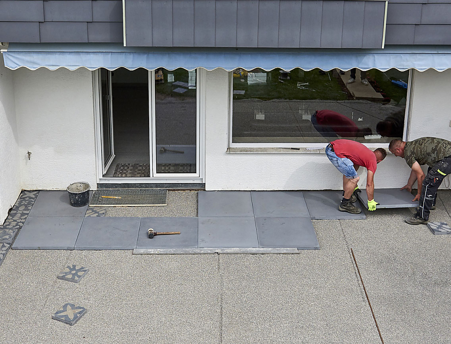 Arbeiter verlegen CEMENTO Terrassenplatten.