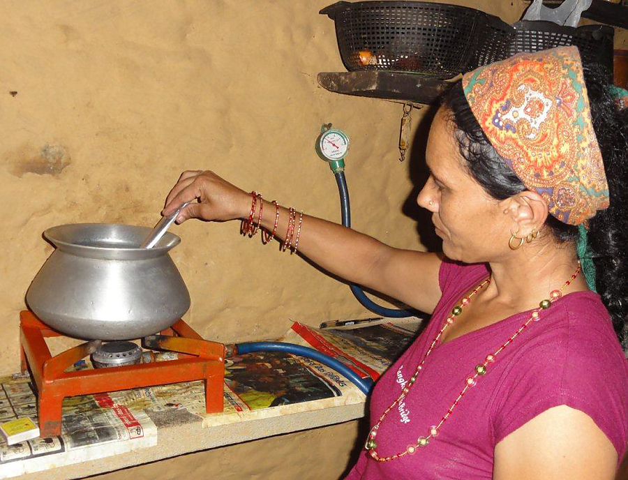 Eine nepalesische Frau kocht.