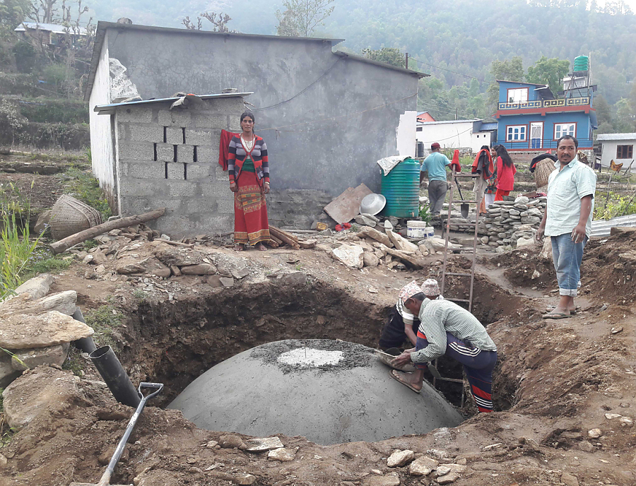 Nepalesische Männer bauen eine Kleinbiogasanlage.