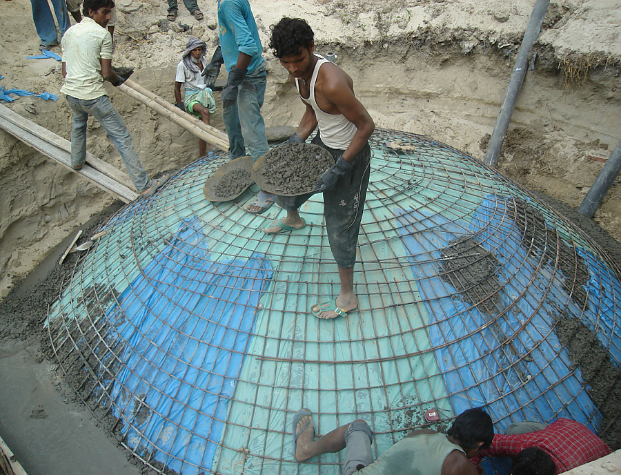 Nepalesische Männer bauen eine Kleinbiogasanlage.