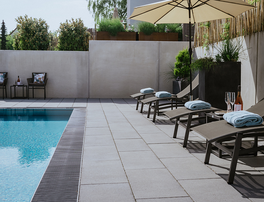 VELVET CONCRETE Terrassenplatten an einem Pool.