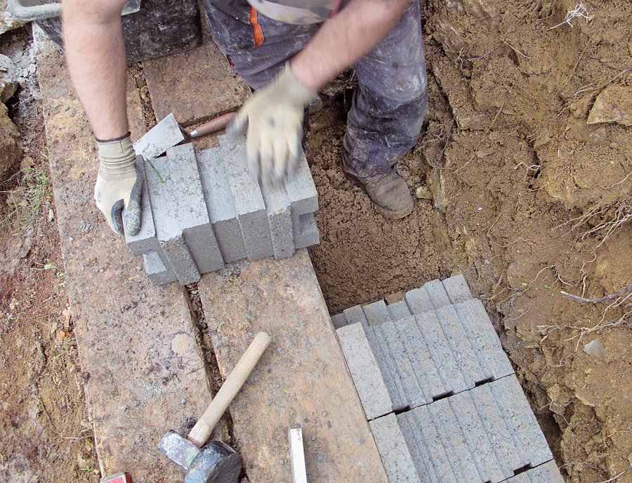 Ein Bauarbeiter setzt ein OCTOPUS Fundamentstein-System