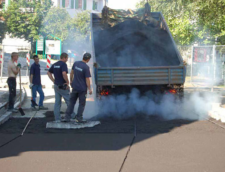 Ein Laster kippt ECOPREC auf eine Straße.