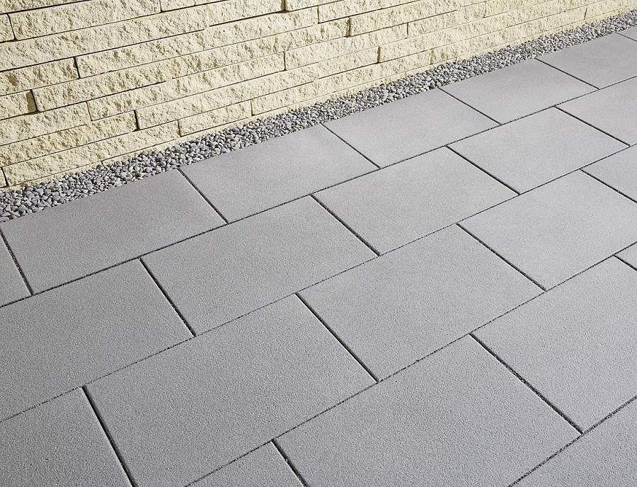 FORUM S Terrassenplatten in der Farbe Naturgrau kombiniert mit CULT LONG-LINE Gartenmauer