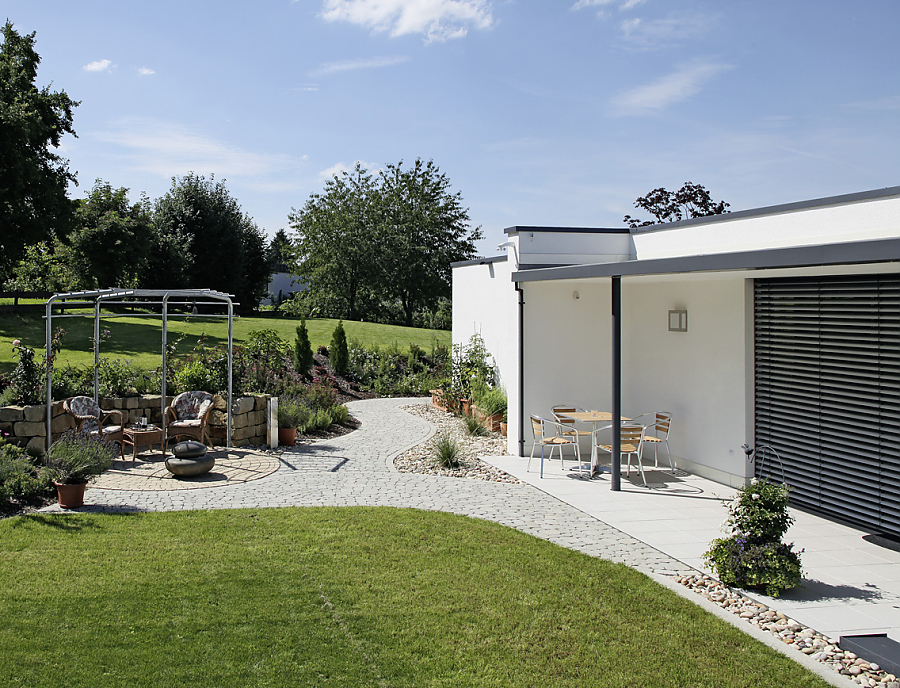 Gartenweg gepflastert mit ARENA-NOVA Pflastersteinen aus Beton in der Farbe Naturgrau