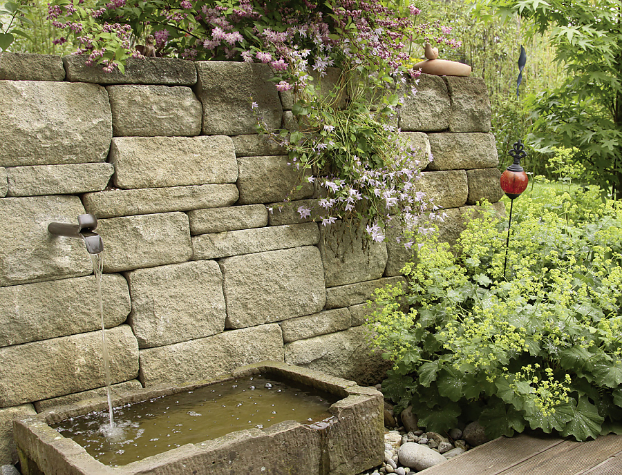 Gartenmauer SANTURO Landhausmauer in der Farbe Schilfsand im Garten mit farblich abgestimmtem Brunnen