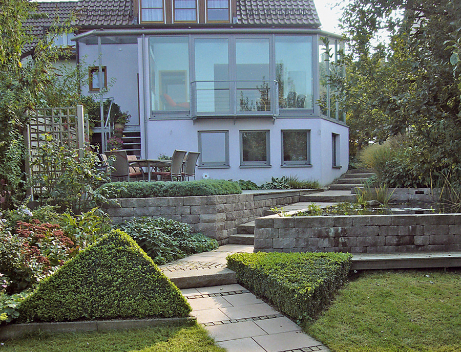 Gartenmauer SANTURO Weinbergmauer Gartenmauer SANTURO Weinbergmauer in der Farbe Naturgrau im Gartenbereich eines Grundstücks als Teichumrandung und als Abgrenzung zur Terrasse