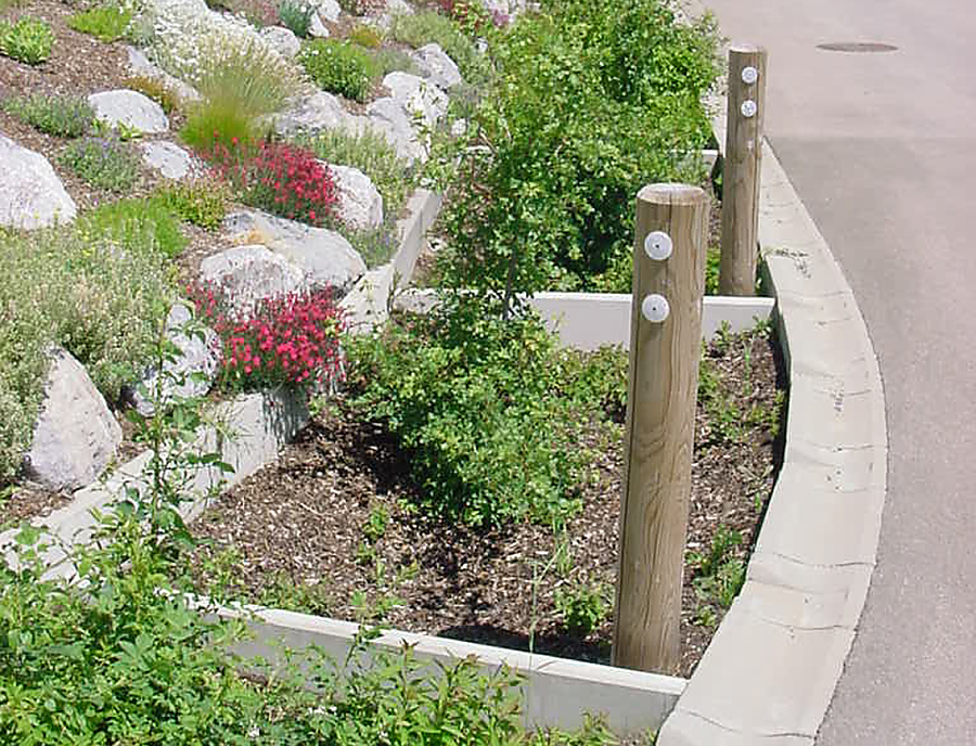 SF Ökorinne in der Farbe Naturgrau an einer Straße mit Ablauf in ein Pflanzenbeet