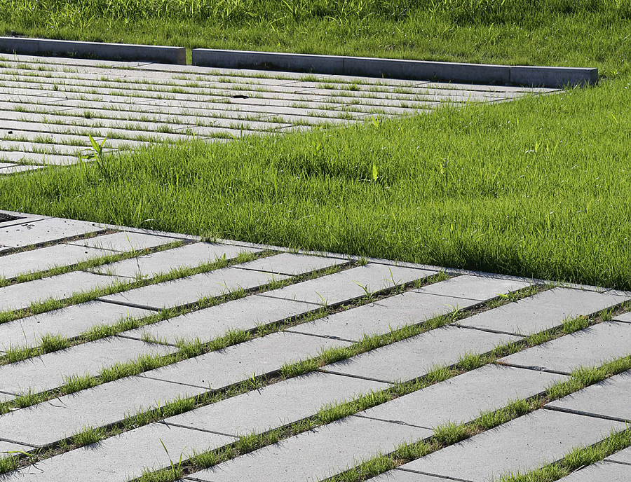 ökologische Pflastersteine SPIRELL Längsrasenfugensteine ökologischer Pflasterstein SPIRELL Längsrasenfugenstein in der Farbe Naturgrau als Parkplatzfläche verlegt
