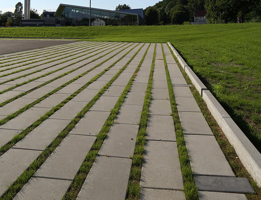 ökologischer Pflasterstein SPIRELL Längsrasenfugenstein in der Farbe Naturgrau als Parkplatzfläche verlegt