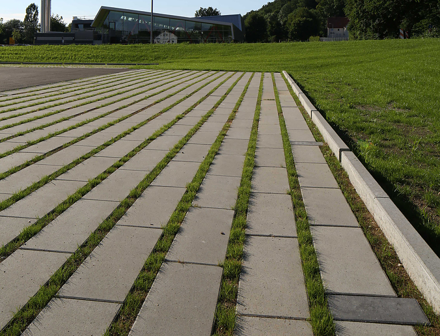 ökologische Pflastersteine SPIRELL Längsrasenfugensteine ökologischer Pflasterstein SPIRELL Längsrasenfugenstein in der Farbe Naturgrau als Parkplatzfläche verlegt