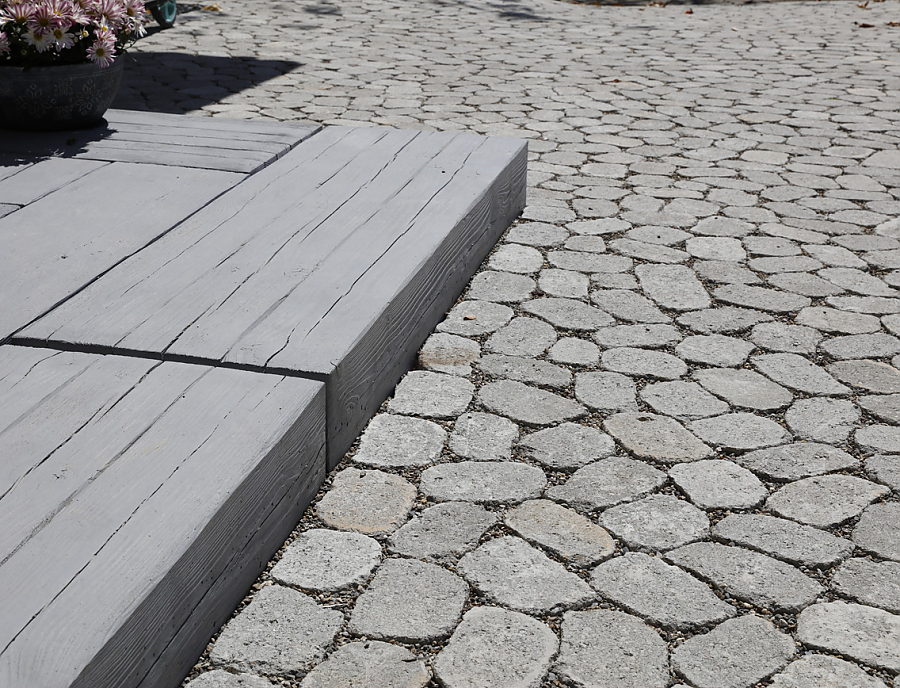 MAHORA Großstufe Holzstrukturstein in der Farbe Mooreiche auf einer Terrasse kombiniert mit ARENA Naturgrau