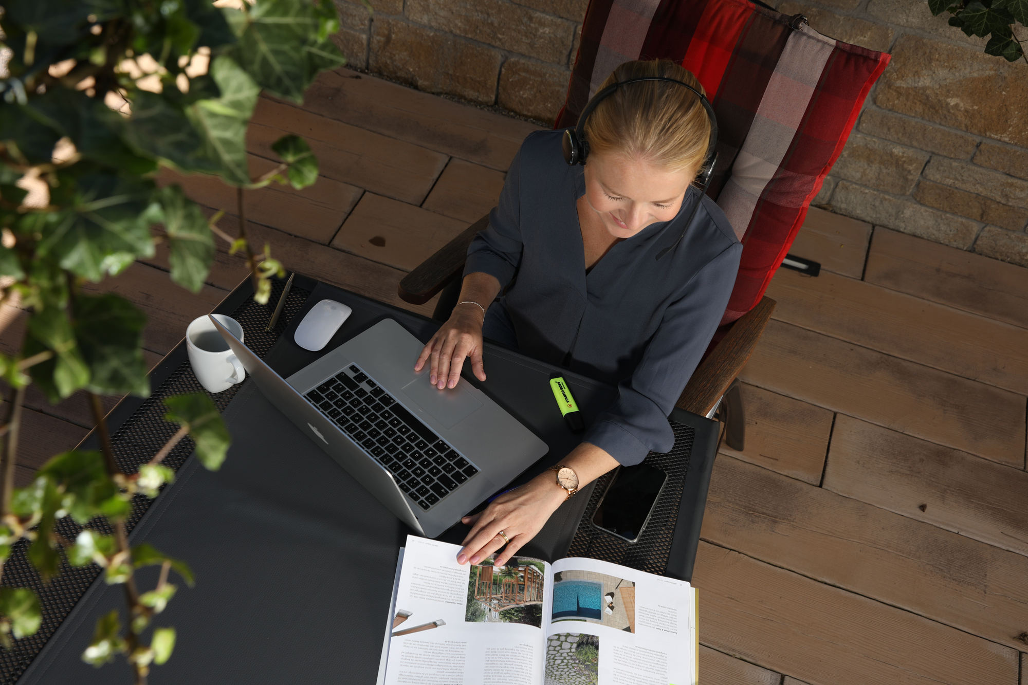 Eine Frau sitzt an einem Arbeitsplatz auf der Terrasse